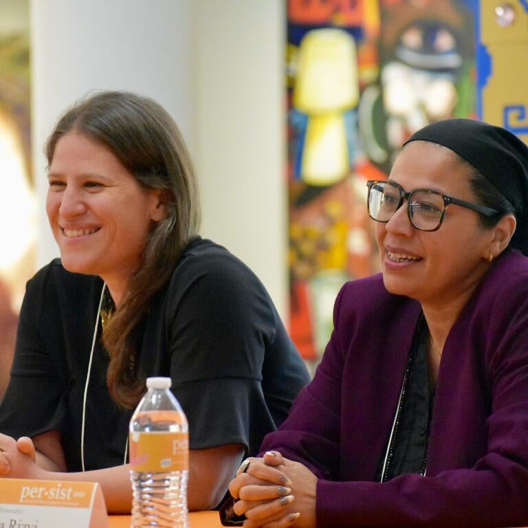 Two women speaking at a panel