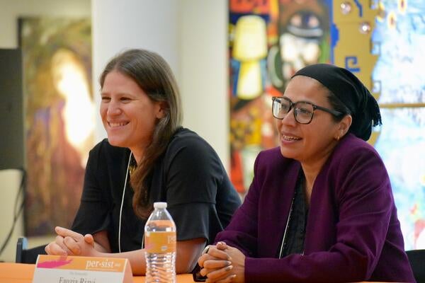 Two women speaking at a panel