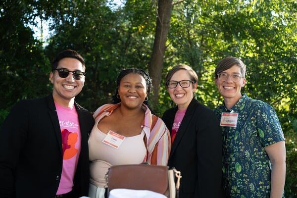 A group of four people smiling